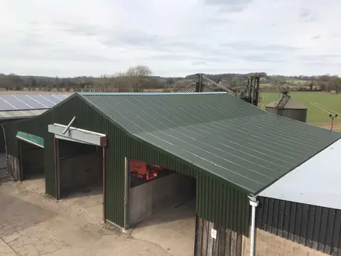 The same farm building finished with green profiled roof sheets and matching green wall cladding